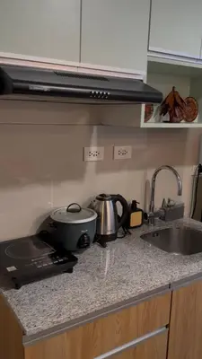 a kitchen counter top with a sink and a stove at Lovekin's Nest at The Verdin in General Trias