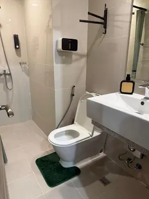 a bathroom with a white toilet and a sink at Lovekin's Nest at The Verdin in General Trias