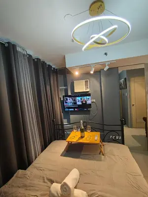 a room with a bed and a table and a tv at Antel Spa & Serenity Suites by Yyess in Manila