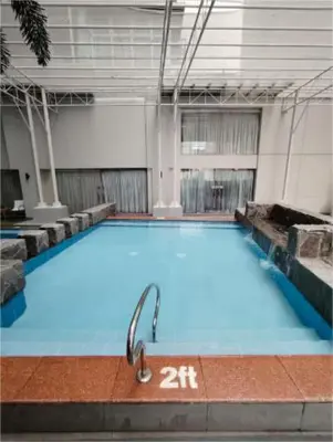 a large swimming pool in a large building at Antel Spa & Serenity Suites by Yyess in Manila