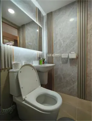 a bathroom with a toilet and a sink and a shower at Antel Spa & Serenity Suites by Yyess in Manila