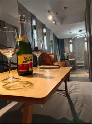 a bottle of wine and a glass on a table at Antel Spa & Serenity Suites by Yyess in Manila