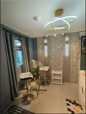 a living room with two stools and a chandelier at Antel Spa & Serenity Suites by Yyess in Manila