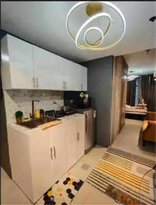 a kitchen with white cabinets and a ceiling at Antel Spa & Serenity Suites by Yyess in Manila
