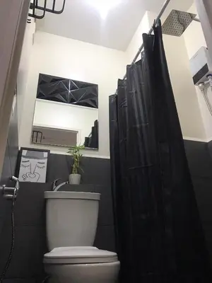 a bathroom with a toilet and a sink and a mirror at InMer's D Staycation in Manila