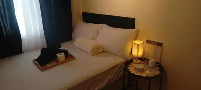 a bedroom with a bed with a candle and a lamp at InMer's D Staycation in Manila