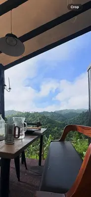 a table and chair with a view of the mountains at Gamay Payag Tagaytay in Calamba