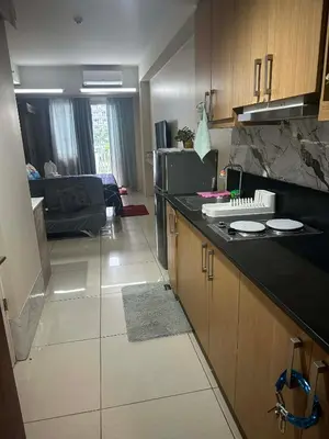 a kitchen with a counter and a living room at AJ Staycation in Manila