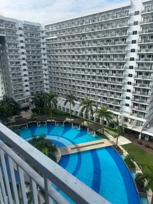 a large apartment building with a large swimming pool at AJ Staycation in Manila