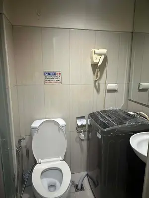 a small bathroom with a toilet and a sink at AJ Staycation in Manila