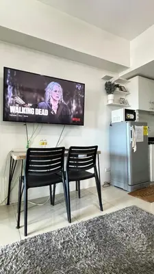 a living room with two chairs and a television on the wall at Jazz Staycation Makati By As in Manila