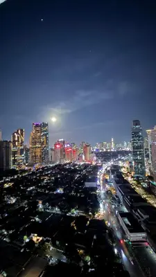 a city lit up at night with traffic at Jazz Staycation Makati By As in Manila