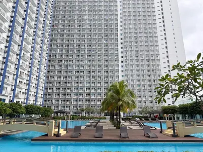 a large building with a pool in front of a building at Jazz Staycation Makati By As in Manila