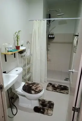 a bathroom with a shower and a toilet and a sink at 1 Bedroom Apartment with Mountain View and WiFi in Manila