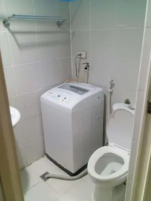 a small bathroom with a toilet and a sink at Suite hotel at Mall of Asia - Tes Ualat in Manila