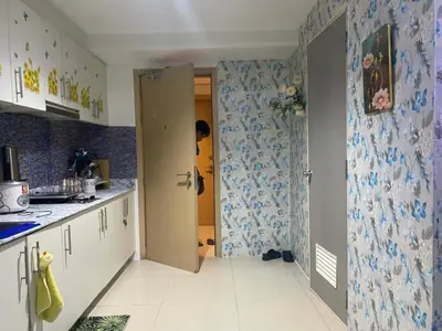 a kitchen with a door leading into a kitchen with a person in it at Suite hotel at Mall of Asia - Tes Ualat in Manila