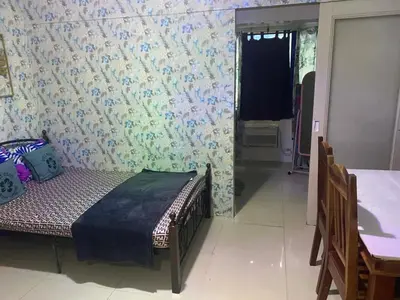 a bedroom with a bed and a table and a window at Suite hotel at Mall of Asia - Tes Ualat in Manila