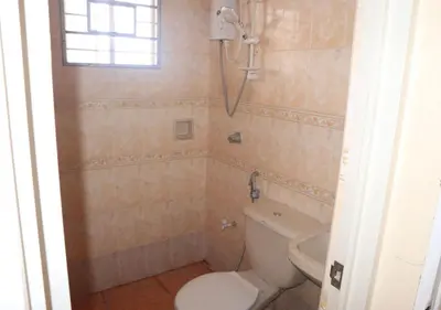 a bathroom with a toilet and a sink at Cool Martin Family Hotel and Resort in Bacoor