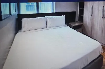 a bed with white sheets and pillows in a room at Luxury 2BR Condo in Makati Near Malls & Offices in Manila