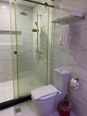 a bathroom with a shower and a toilet and a toilet paper roll at Sun Star Grand Hotel in Manila