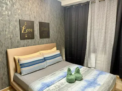 two green shoes sitting on top of a bed at The Gramercy Residences in Manila
