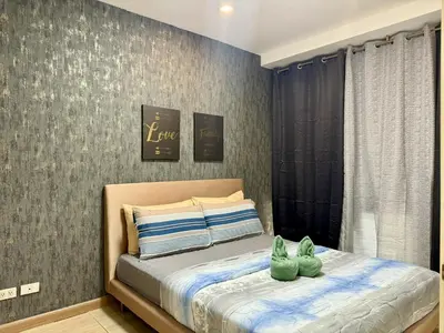 two green cats sitting on a bed in a bedroom at The Gramercy Residences in Manila