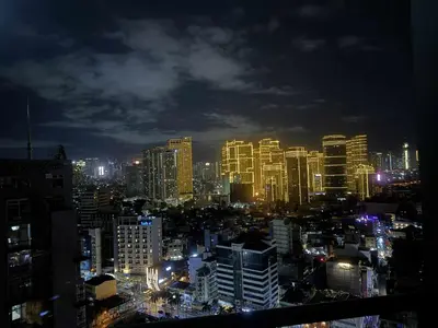 a city skyline at night with lit buildings at The Gramercy Residences in Manila