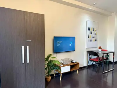 a living room with a tv and a table at The Gramercy Residences in Manila
