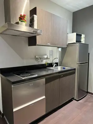 a kitchen with a stainless steel refrigerator and a sink at The Gramercy Residences in Manila