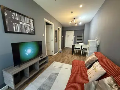 a living room with a couch and a flat screen tv at The Gramercy Residences in Manila