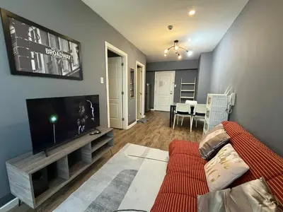 a living room with a couch and a flat screen tv at The Gramercy Residences in Manila