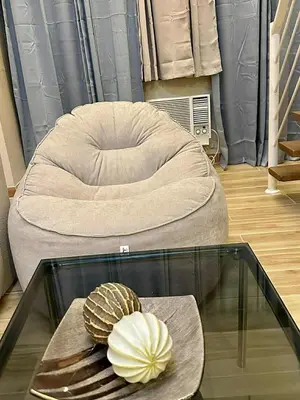 a room with a chair and a glass table at The Gramercy Residences in Manila