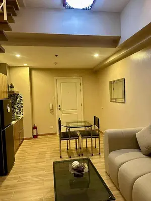 a living room with a couch and a table at The Gramercy Residences in Manila