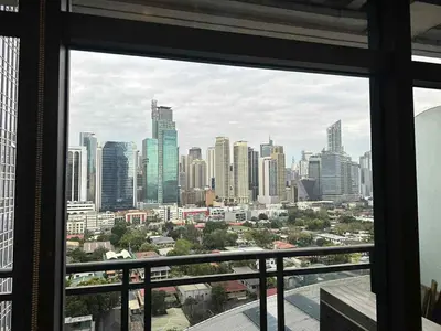 a view of a city skyline from a window at The Gramercy Residences in Manila