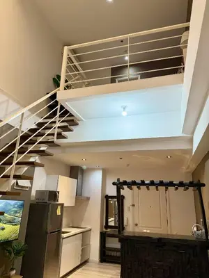 a kitchen with a spiral staircase in a house at The Gramercy Residences in Manila