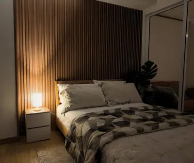 a bedroom with a large bed and a lamp at Azure Residences Staycation in Manila