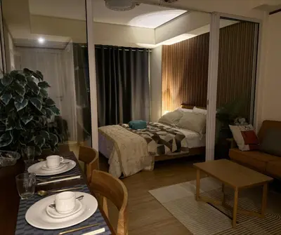 a living room with a bed and a table with chairs at Azure Residences Staycation in Manila