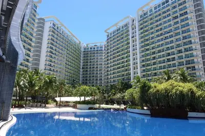 a large building with a large swimming pool in front of it at Azure Residences Staycation in Manila