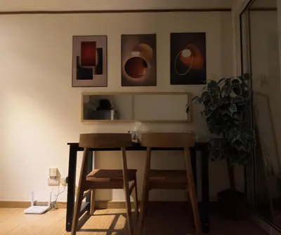 a table and two chairs in a room with pictures on the wall at Azure Residences Staycation in Manila