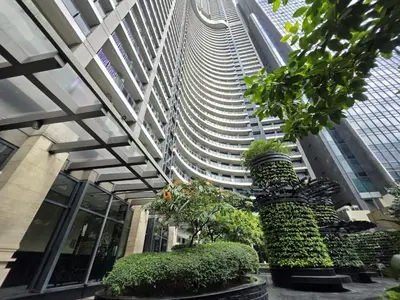 a tall building with plants in front of it at Stay in Makati 1-BR Condo with Pool, Fast WiFi, Gym, Balcony in Manila