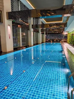 a large swimming pool with blue tiles on the floor at Stay in Makati 1-BR Condo with Pool, Fast WiFi, Gym, Balcony in Manila