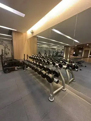 a gym with a row of exercise bikes and a mirror at Mall of Asia residence shore 3 in Manila