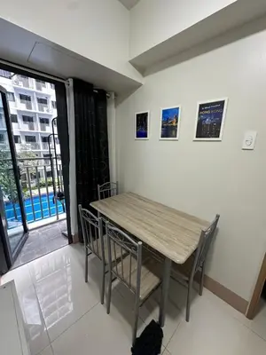 a dining room with a wooden table and chairs at Mall of Asia residence shore 3 in Manila