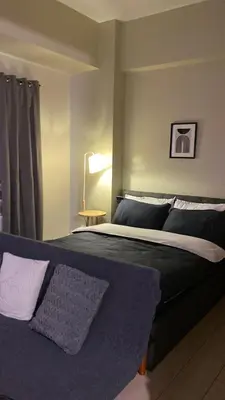 a bedroom with a large bed and a lamp at Cluster 3, 81 Newport Blvd near NAIA T3 in Manila