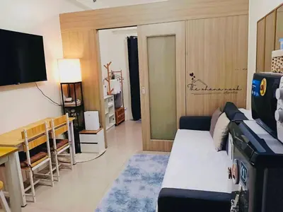 a living room with a couch and a table and a television at The Ohana Nook in Manila