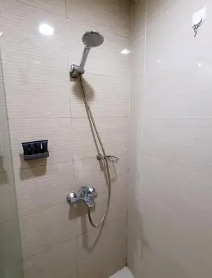 a shower with a shower head in a bathroom at Urban Studio with Balcony in Manila
