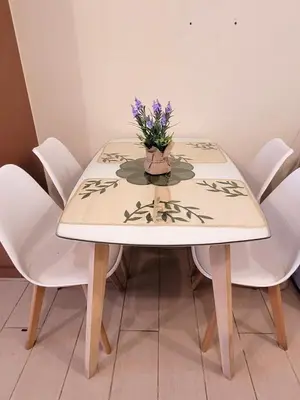 a table with white chairs and a vase with purple flowers at Urban Studio with Balcony in Manila