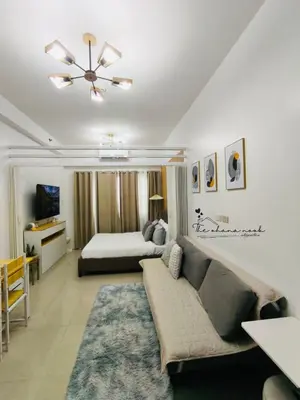 a living room with a couch and a bed at The Hearth Bliss in Manila