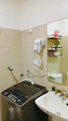 a bathroom with a sink and a toilet and a mirror at The Hearth Bliss in Manila