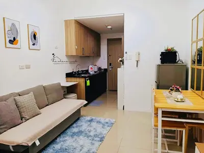 a living room with a couch and a kitchen at The Hearth Bliss in Manila
